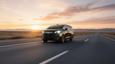 Black SUV driving on desert highway at sunset with mountains in background