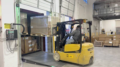 Yellow Yale forklift moving boxes in industrial warehouse storage area