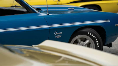 Blue vintage Chevrolet Camaro with white stripe, side view
