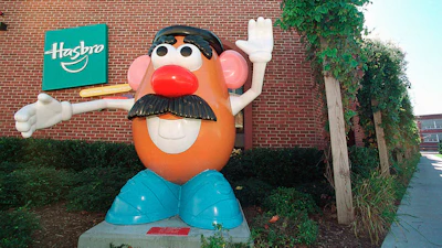 Large Mr. Potato Head statue outside Hasbro building with green logo