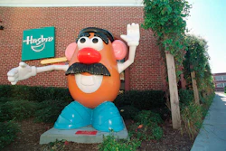 Large Mr. Potato Head statue outside Hasbro building with green logo