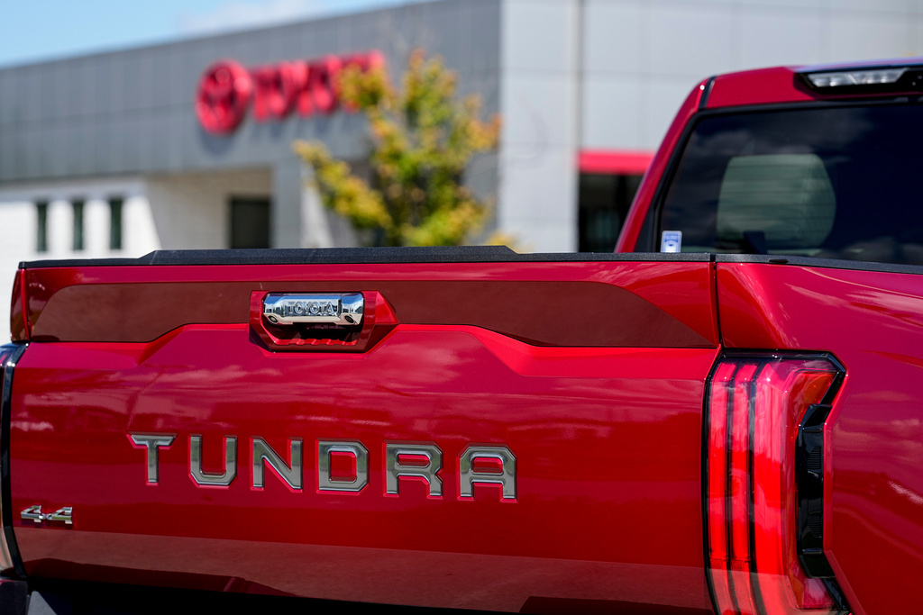 Red Toyota Tundra pickup truck with 4x4 badge, parked near a building
