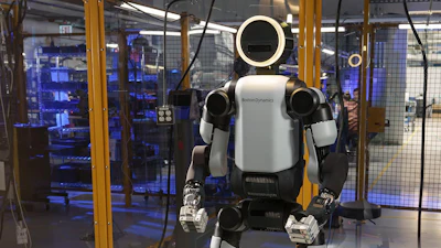Humanoid robot with white and black body standing in industrial laboratory