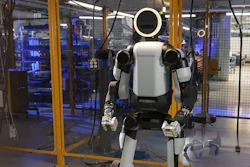 Humanoid robot with white and black body standing in industrial laboratory