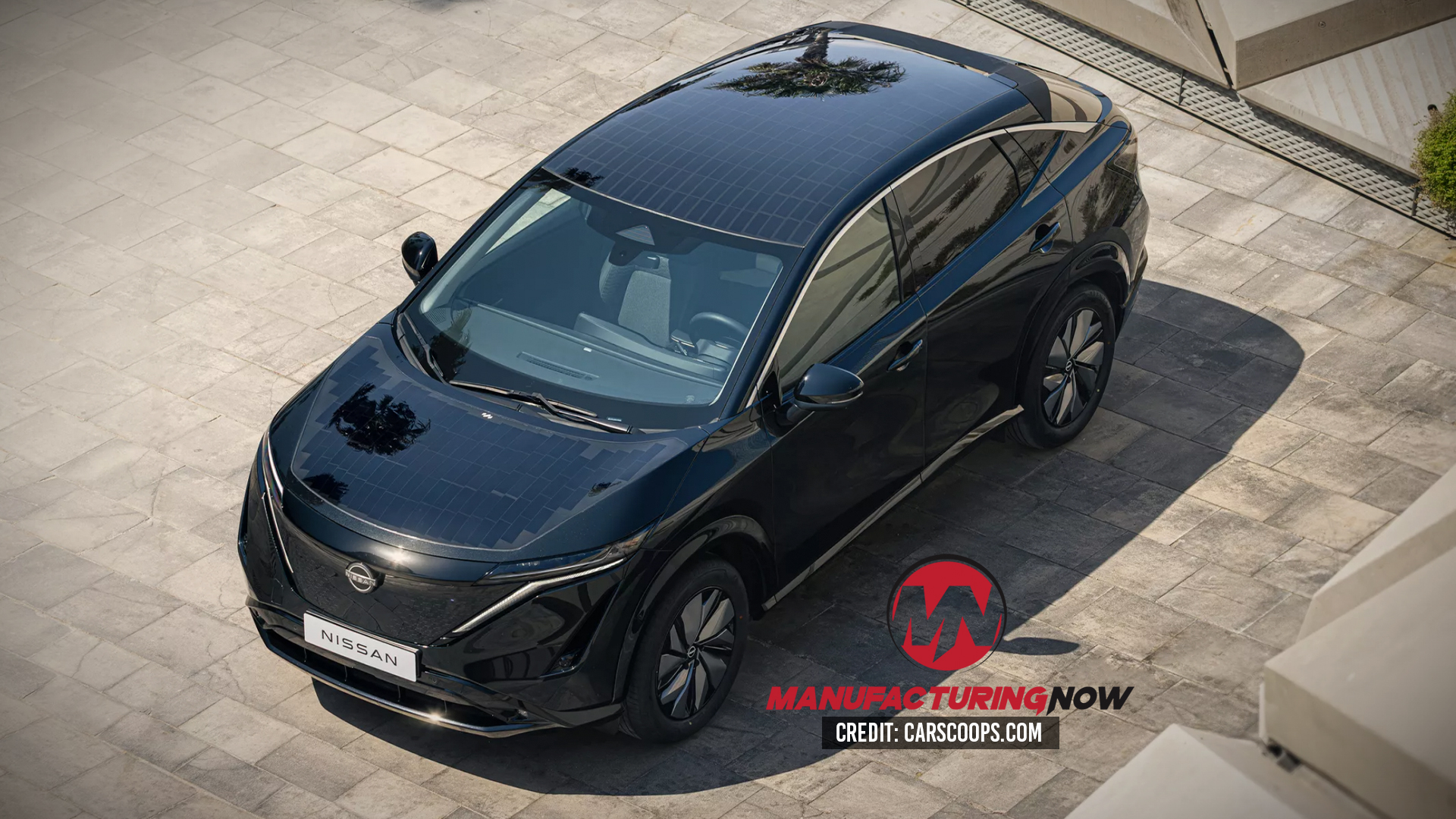 Black Nissan electric SUV parked on tiled surface with solar roof