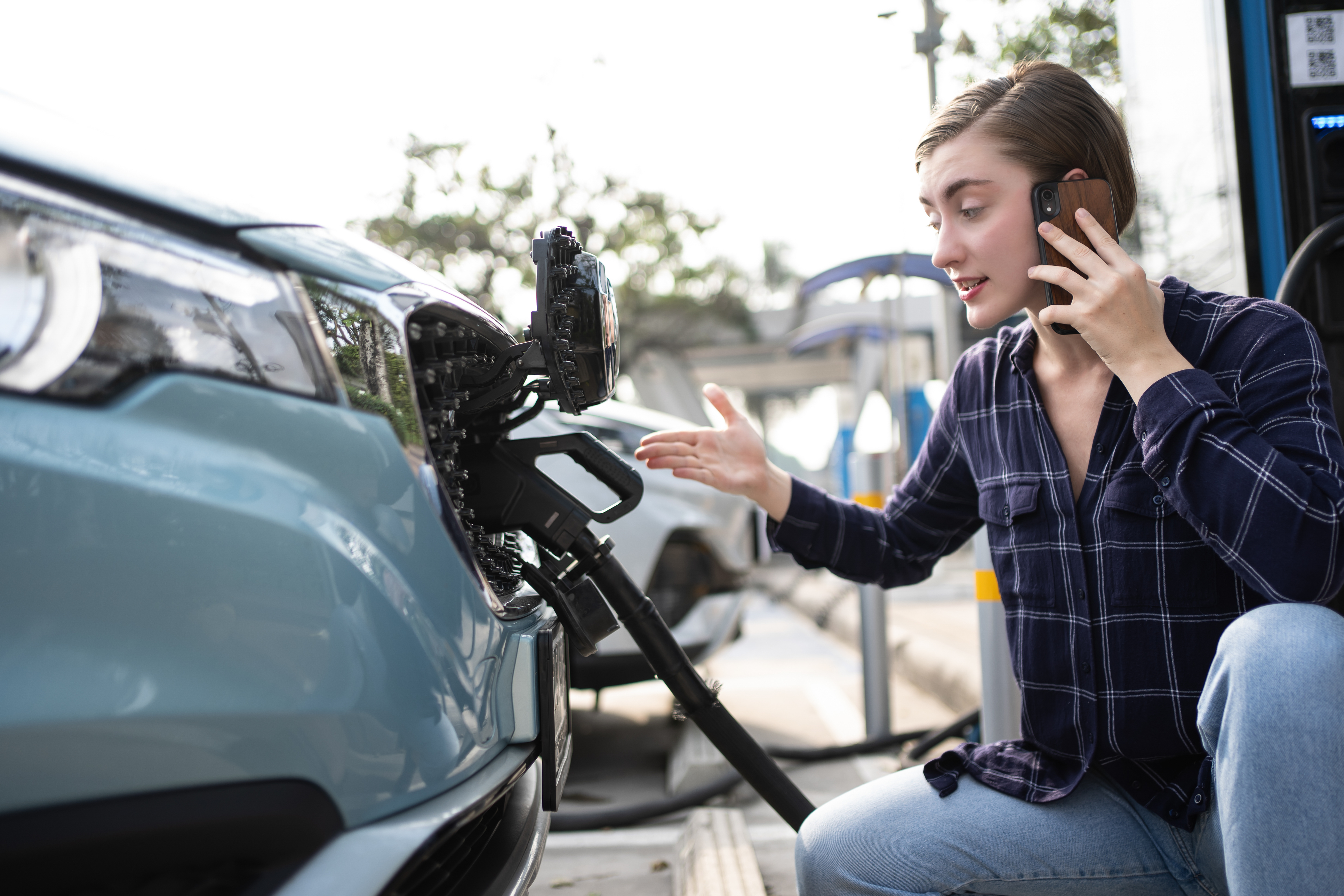 Person charging an electric vehicle at a charging station