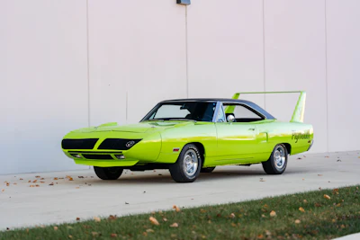 Lime green 1970 Plymouth Superbird with distinctive rear wing parked on concrete