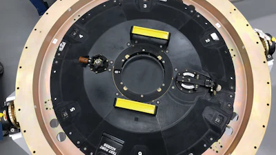 Circular mechanical device with black surface, numbered sections, and yellow markers