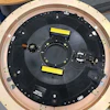 Circular mechanical device with black surface, numbered sections, and yellow markers
