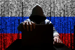 Hooded cybersecurity figure against Russian flag with digital code background