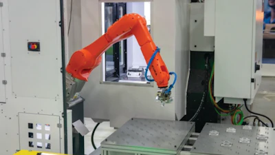 Orange industrial robotic arm performing precision manufacturing task
