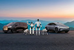 Futuristic electric vehicles and humanoid robots at sunset with mountain backdrop