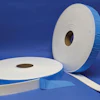 Two rolls of white foam sealing tape on blue background