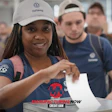 Smiling woman in Volkswagen cap and Manufacturing Now shirt at corporate event with colleagues
