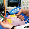 Technician testing electronic circuit board with blue compressed air gun