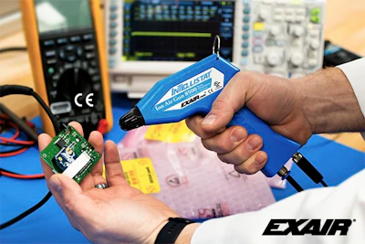 Technician testing electronic circuit board with blue compressed air gun
