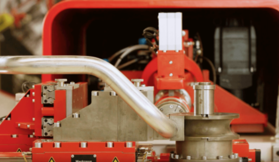 Red industrial machinery with metal pipes and mechanical components