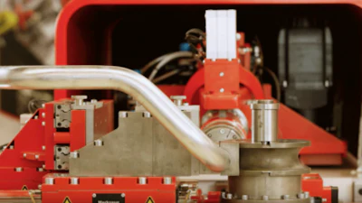 Red industrial machinery with metal pipes and mechanical components