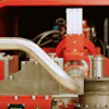 Red industrial machinery with metal pipes and mechanical components