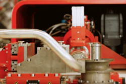 Red industrial machinery with metal pipes and mechanical components