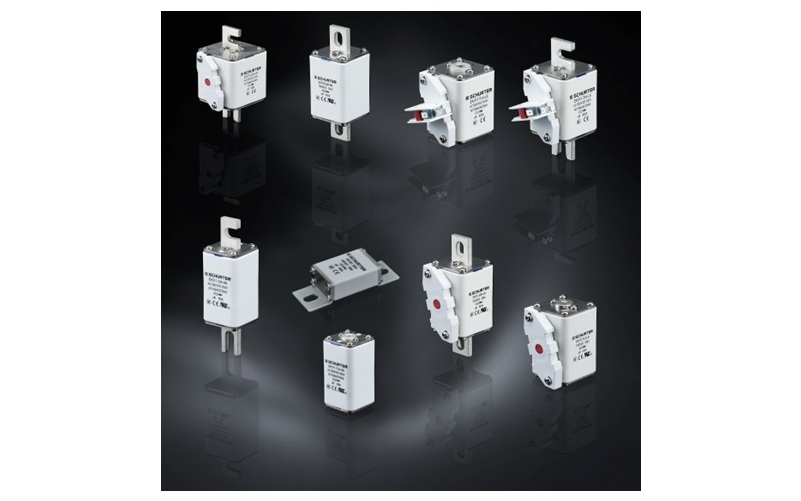 White industrial electrical components and circuit protection devices on dark background