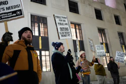 Protesters holding signs advocating for public transit funding and against Elon Musk's involvement in transit projects
