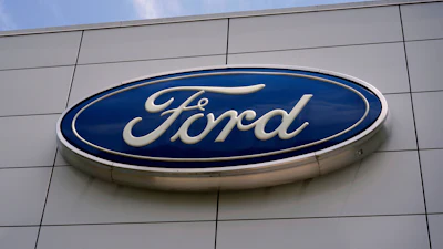 Ford logo mounted on gray building exterior signage