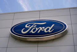 Ford logo mounted on gray building exterior signage