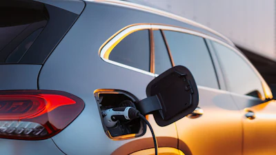 Electric vehicles charging at an outdoor charging station during golden hour