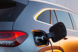 Electric vehicles charging at an outdoor charging station during golden hour