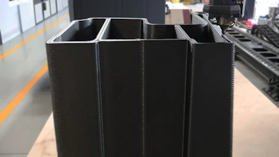Black four-compartment storage container in industrial warehouse setting