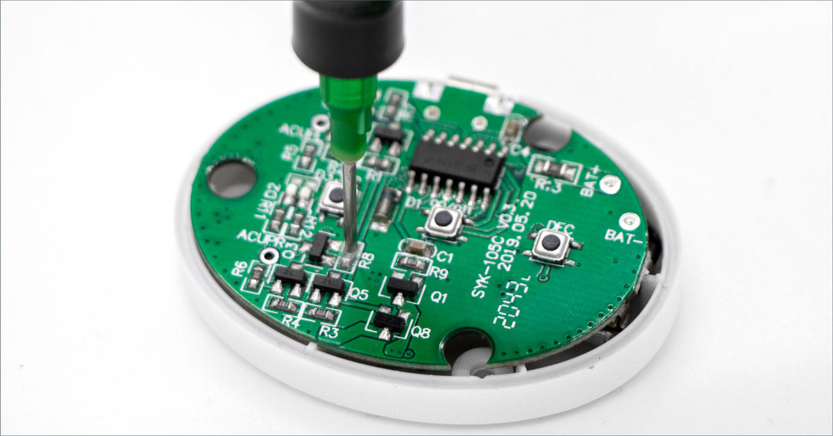 Green circuit board with integrated components and black antenna connector mounted on white housing