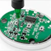 Green circuit board with integrated components and black antenna connector mounted on white housing