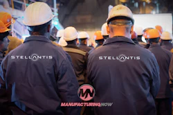 Construction workers wearing Stellantis-branded jackets and hard hats at a nighttime job site