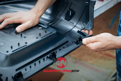 Technician assembling black plastic component with multiple fasteners during manufacturing process