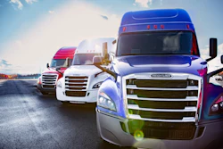 Fleet of colorful semi-trucks parked in a row under blue sky with clouds