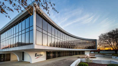 Modern EnerSys corporate headquarters building with curved glass facade and white exterior at sunset