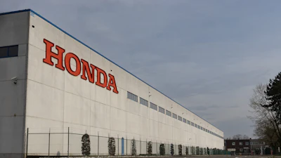Honda manufacturing facility with red brand lettering on white industrial building facade