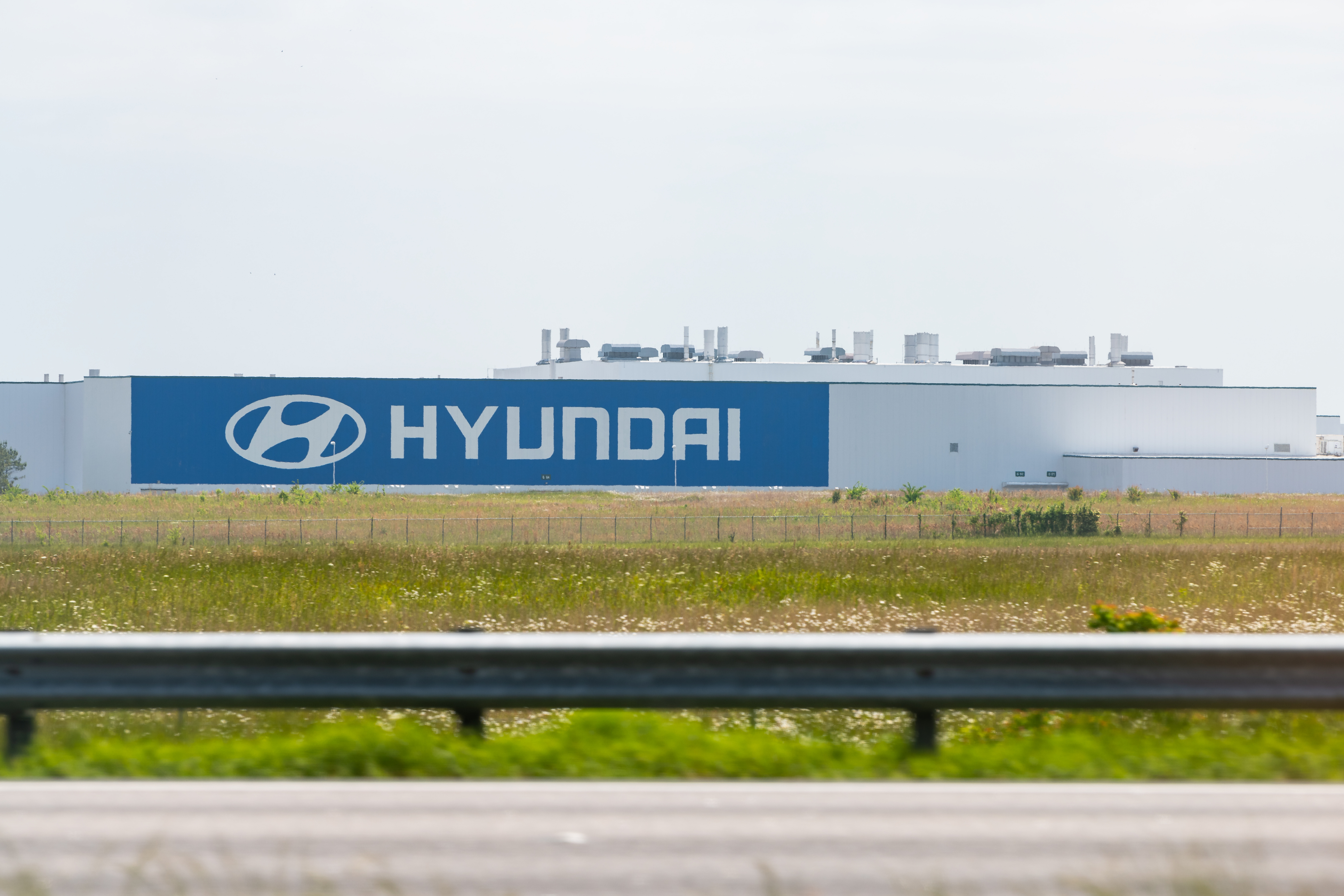 Hyundai manufacturing facility with blue branded signage along highway