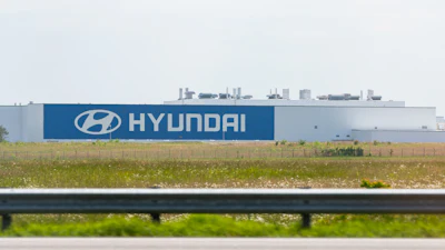 Hyundai manufacturing facility with blue branded signage along highway