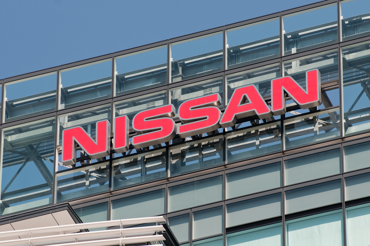 Nissan red logo signage mounted on modern glass building facade