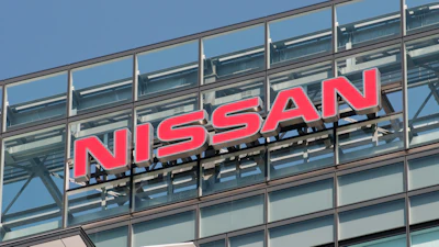 Nissan red logo signage mounted on modern glass building facade
