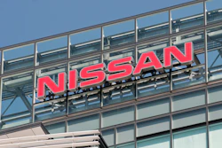 Nissan red logo signage mounted on modern glass building facade