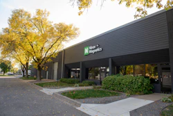 Niron Magnetics storefront with dark modern building facade and autumn trees in background