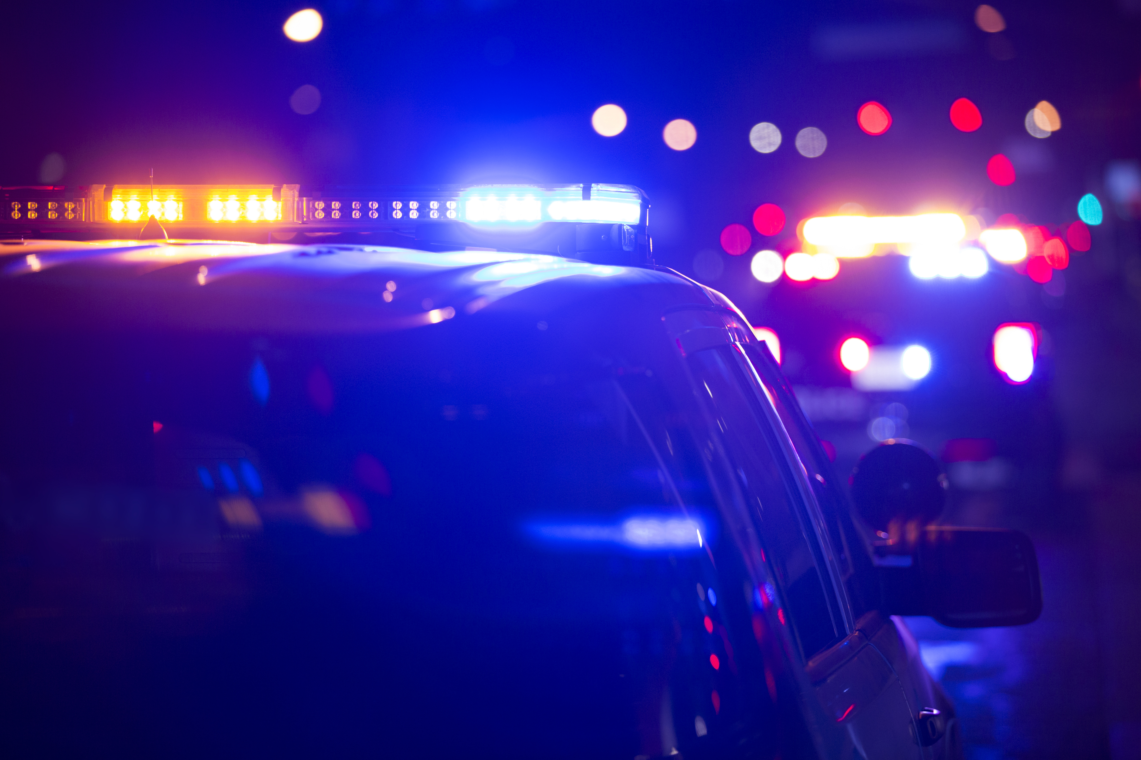 Police vehicle with flashing blue and red emergency lights at night