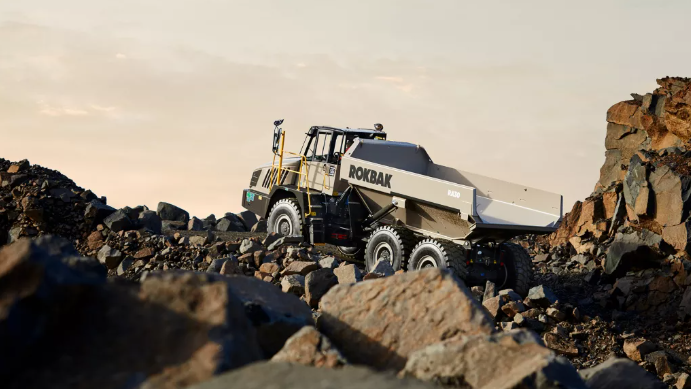 Rokbak articulated dump truck navigating rocky quarry terrain with large boulders