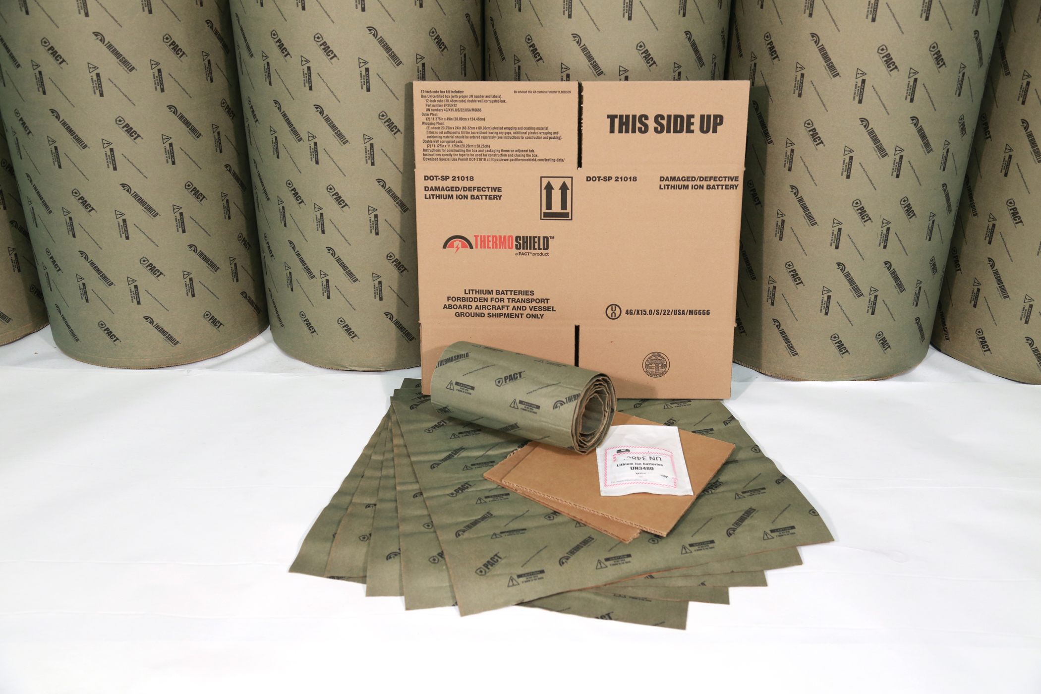 Thermal Shield insulation material rolls with cardboard packaging box and product samples displayed on white surface