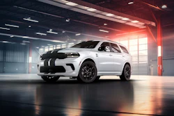 White Dodge Durango with black racing stripes parked in modern garage with dramatic red and warm lighting