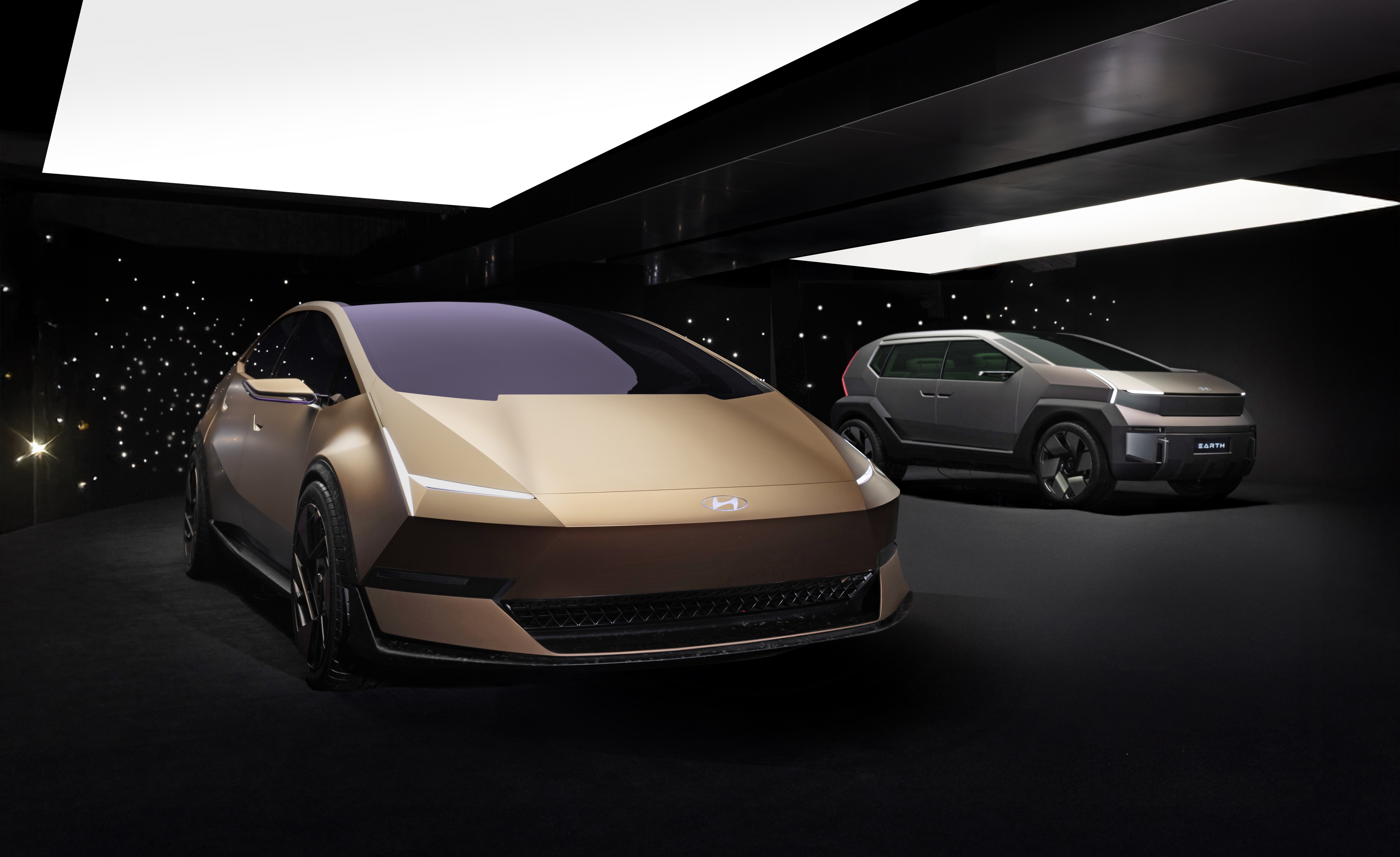 Hyundai concept electric vehicles displayed in modern showroom with ambient lighting