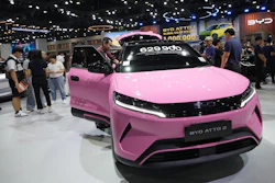 Pink BYD Atto 2 electric vehicle on display at auto show with price tag and visitors